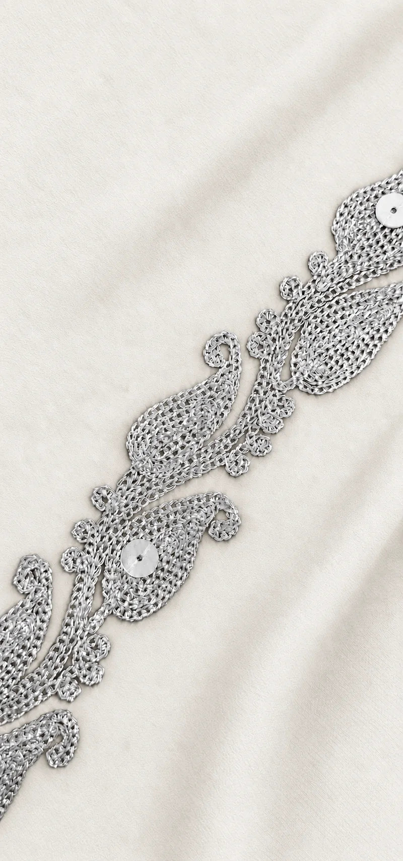 Close-up of silver Zari embroidery on white fabric